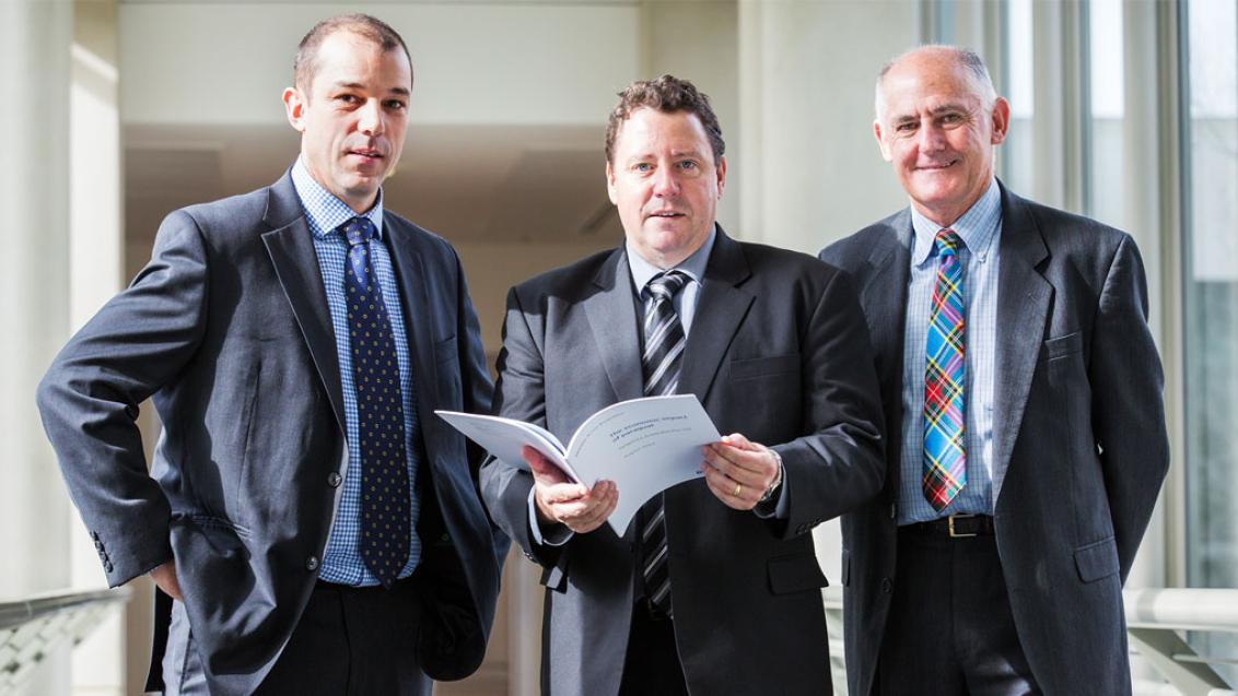 three men in suits standing