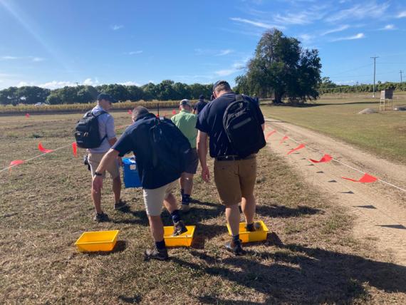 biosecurity activity involving individuals stepping into shallow yellow trays