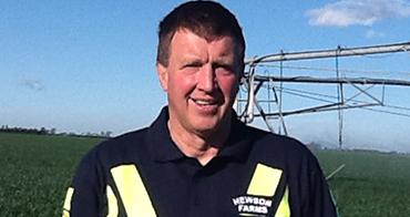 Man in front of crop sprayers