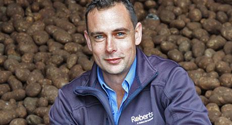 Stuart Millwood in front of harvested potatoes 