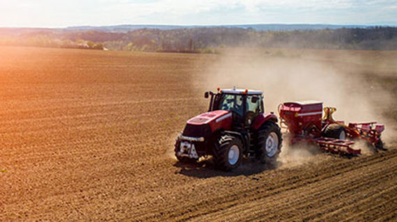 tractor plowing through dirt field 