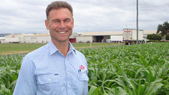 man smiling in front of crops 