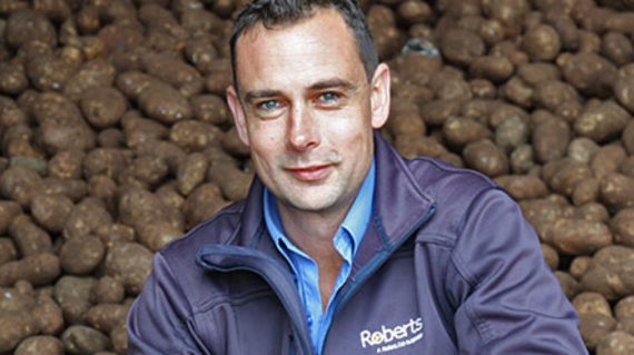 Stuart Millwood in front of harvested potatoes 
