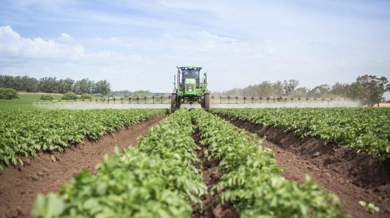 boom spray tractor in potato field