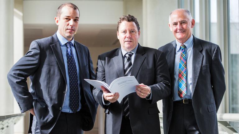 three men in suits standing
