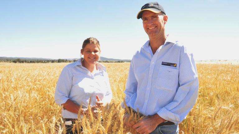 farmers smiling in front of field Pete Wilson from Lachlan Fertilizers Rural, Cowra (right) with Syngenta Territory Sales Manager, Emma McClelland in the BOXER GOLD treated paddock of Gregory wheat. 