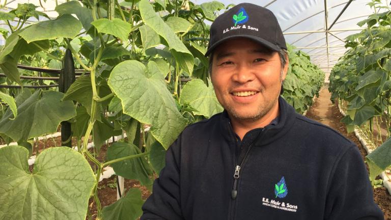 man standing next to plant